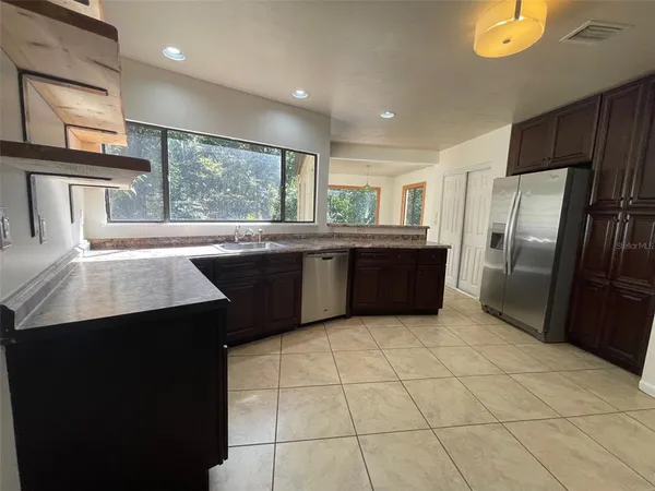 a kitchen with stainless steel appliances granite countertop a refrigerator a sink a stove and island