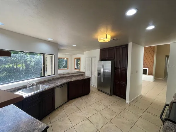 a large kitchen with stainless steel appliances granite countertop a refrigerator and a sink