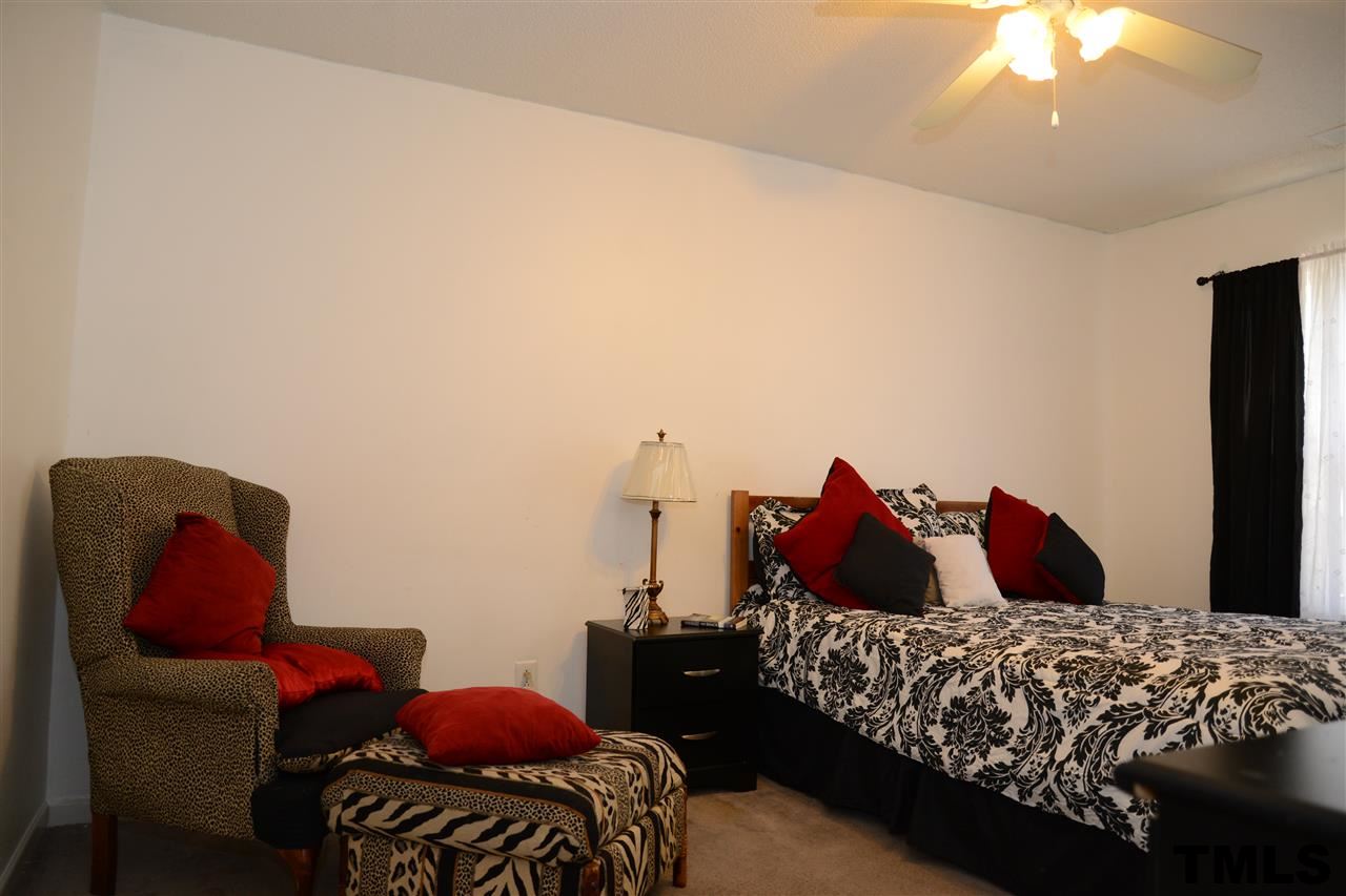8116 Inverbrass Court Raleigh, NC 27616 - Photo 19 of 25 a bedroom with a bed and a chandelier