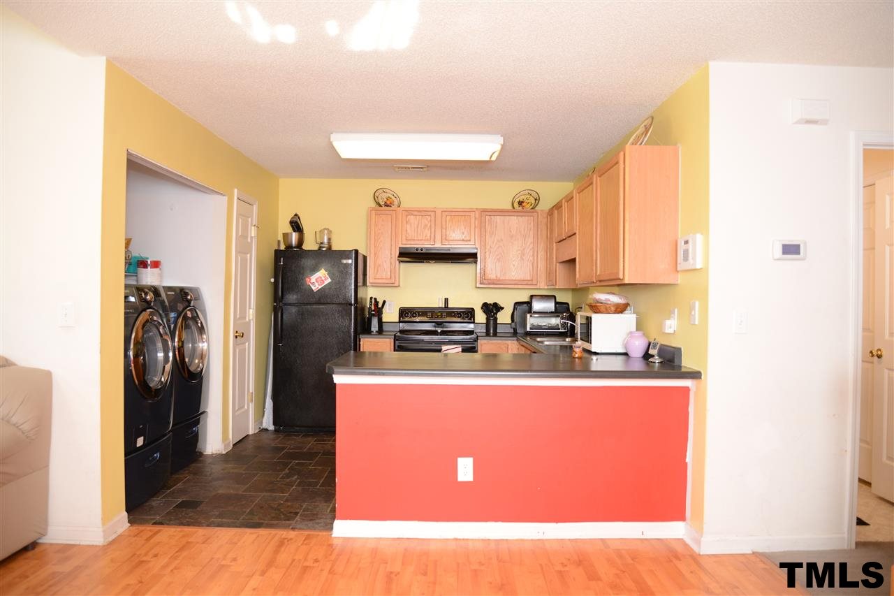 8116 Inverbrass Court Raleigh, NC 27616 - Photo 8 of 25 a kitchen with stainless steel appliances granite countertop a refrigerator a stove and a sink with large cabinets
