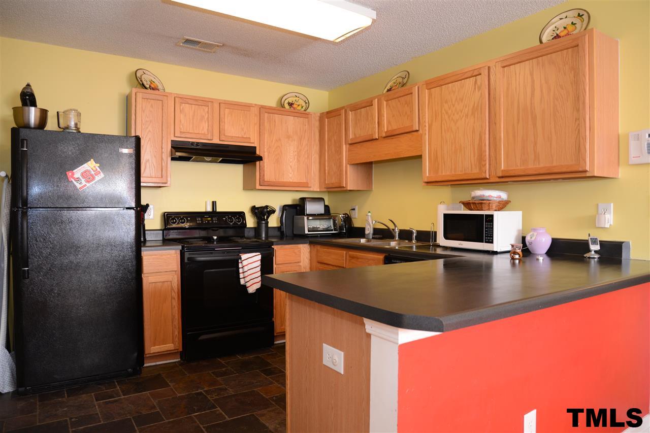 8116 Inverbrass Court Raleigh, NC 27616 - Photo 9 of 25 a kitchen with stainless steel appliances granite countertop a refrigerator a stove a sink dishwasher and cabinets with wooden floor
