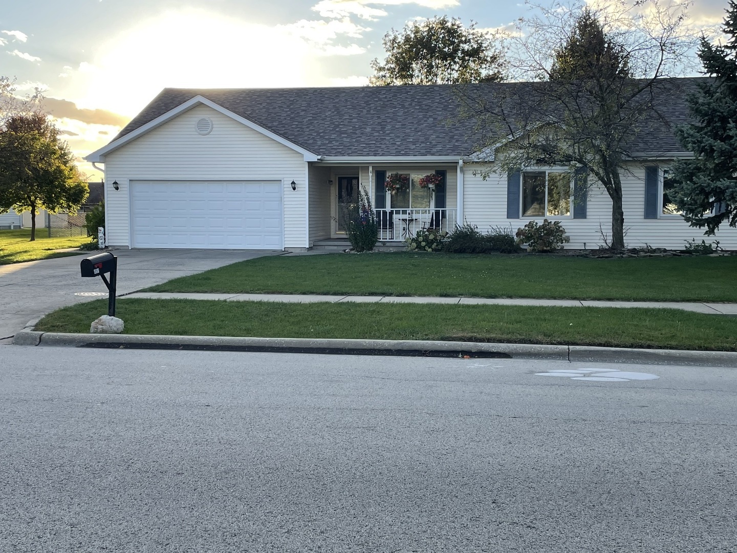 a front view of a house with a garden and garage