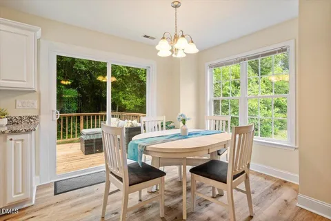 a dining room with furniture a chandelier and wooden floor