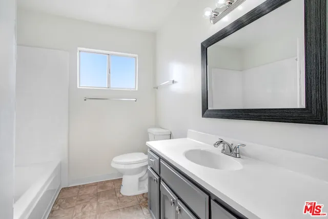 a bathroom with a sink vanity mirror and toilet