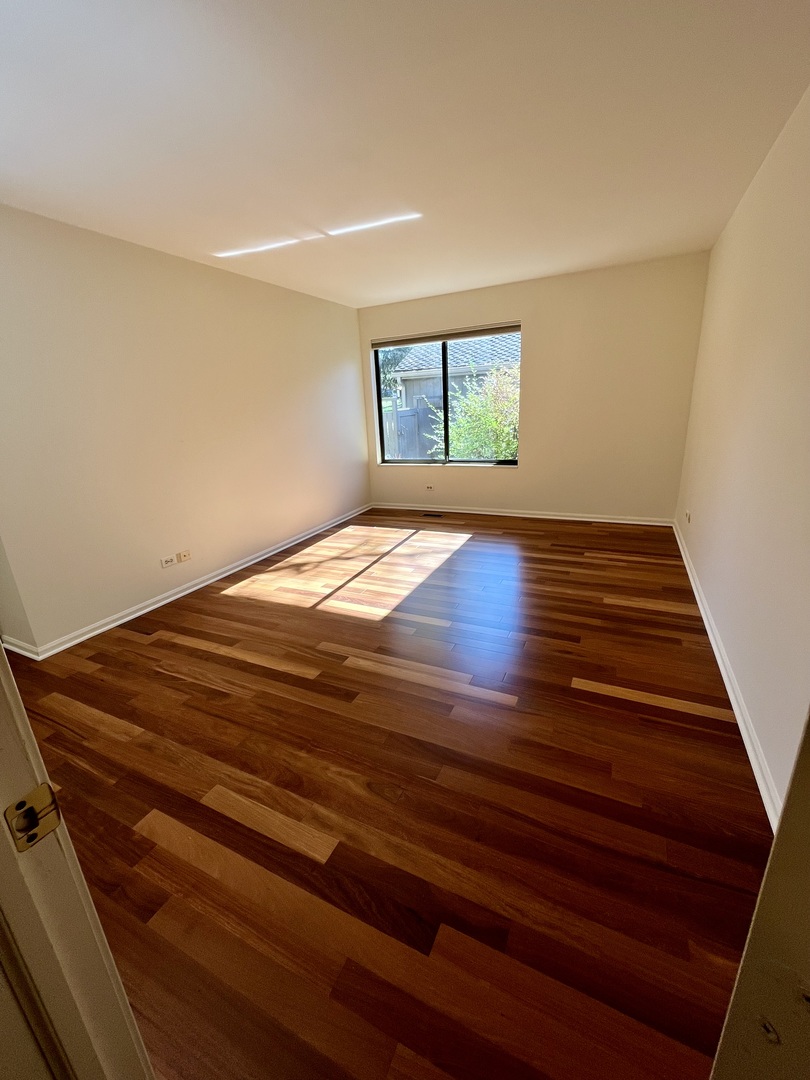 315 Bluff Court, Unit C Lake Barrington, IL 60010 - Photo 14 of 43 a view of empty room with wooden floor and fan