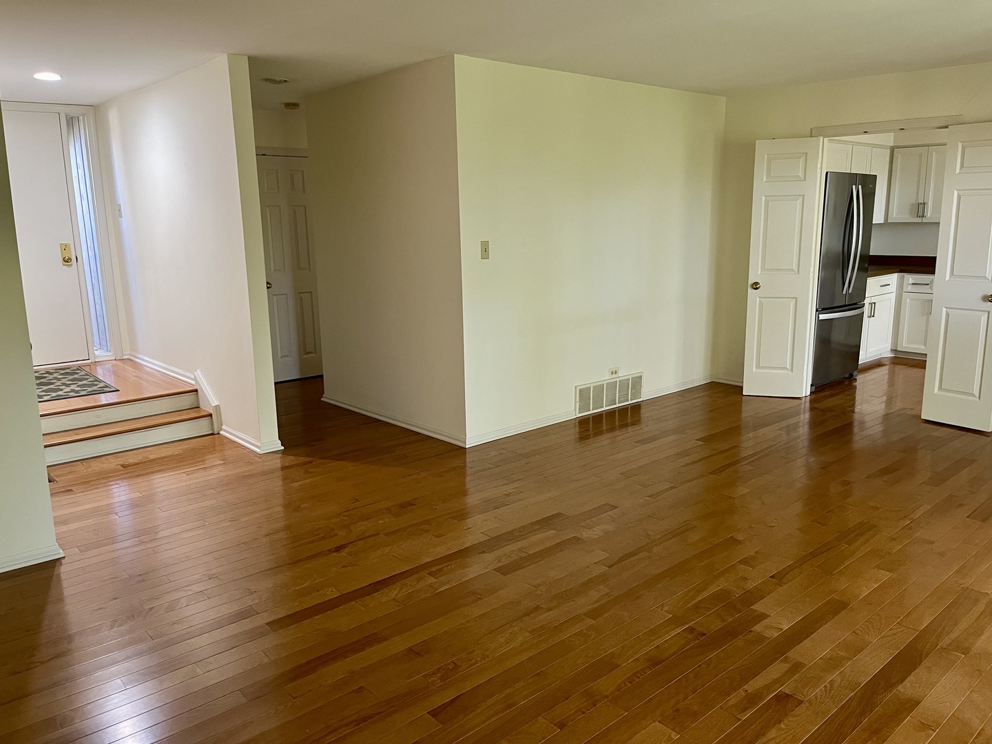 315 Bluff Court, Unit C Lake Barrington, IL 60010 - Photo 5 of 43 an empty room with wooden floor and a kitchen