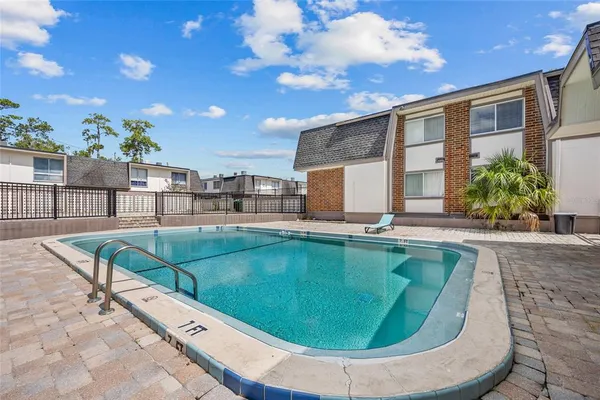 an aerial view of a house with swimming pool and furniture