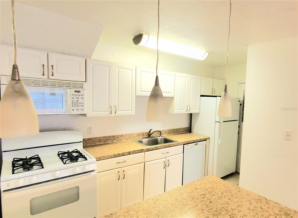 1700 Southwest 16th Court, Unit E29 Gainesville, FL 32608 - Photo 5 of 15 a kitchen with stainless steel appliances granite countertop a sink a stove and a refrigerator