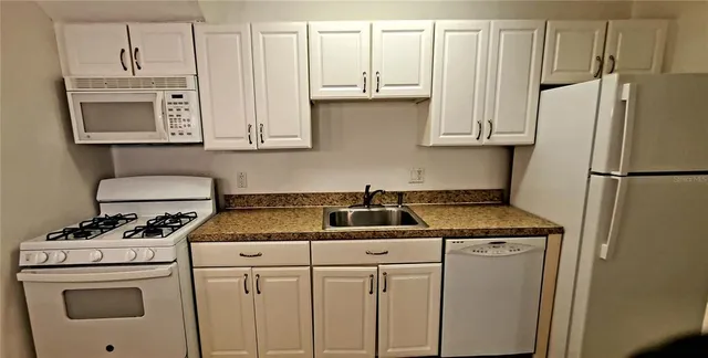 a kitchen with appliances a sink and cabinets