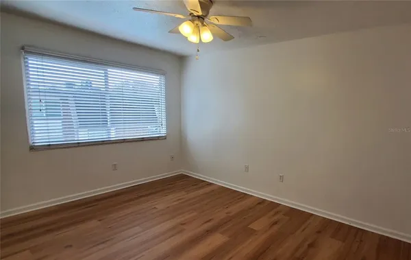 a view of a room with wooden floor and a window