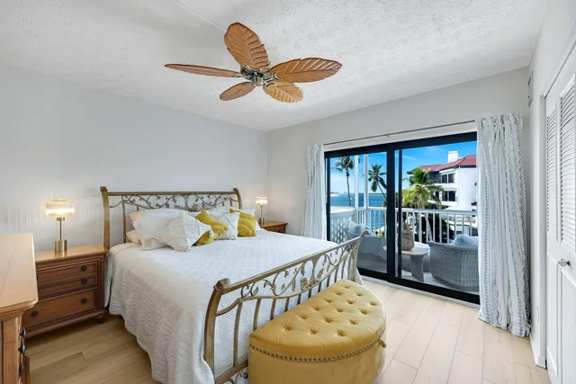 a bedroom with a bed and dresser with wooden floor