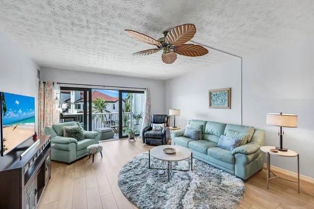 a living room with furniture ceiling fan and a window