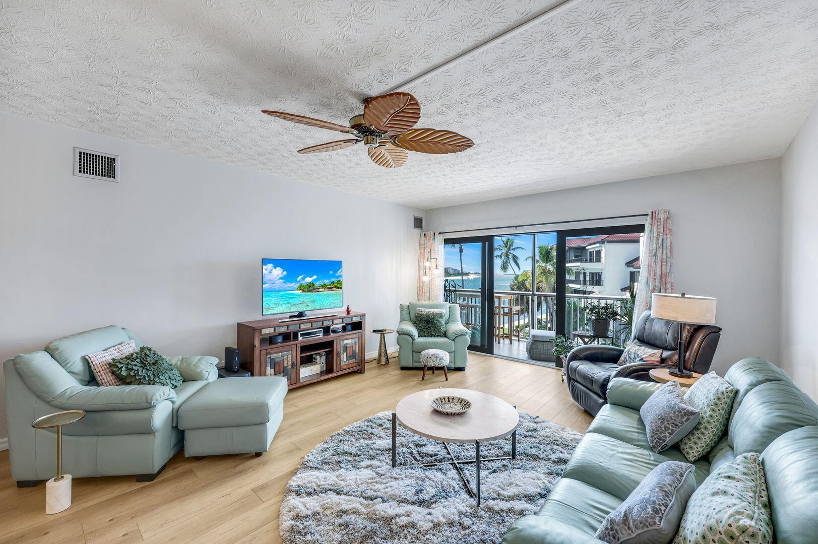 60 West Pelican Street, Unit 407 Naples, FL 34113 - Photo 6 of 26 a living room with furniture a rug a window and a flat screen tv