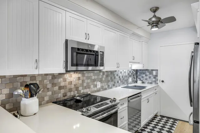 a kitchen with a sink stove and white cabinets