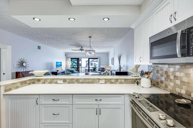 a view of a kitchen counter top a stove and cabinets