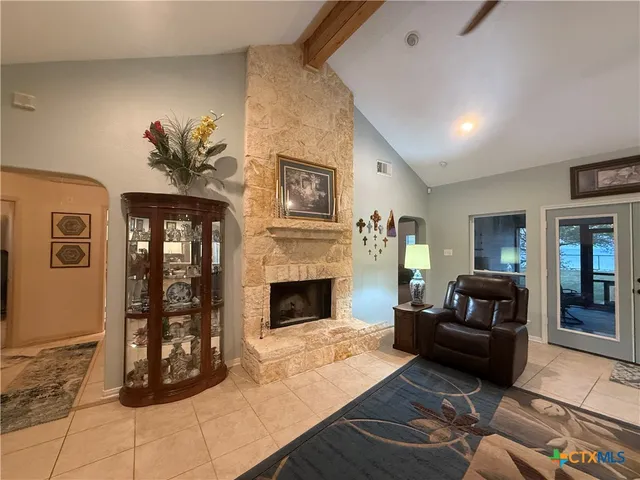 a living room with furniture a flat screen tv and kitchen view