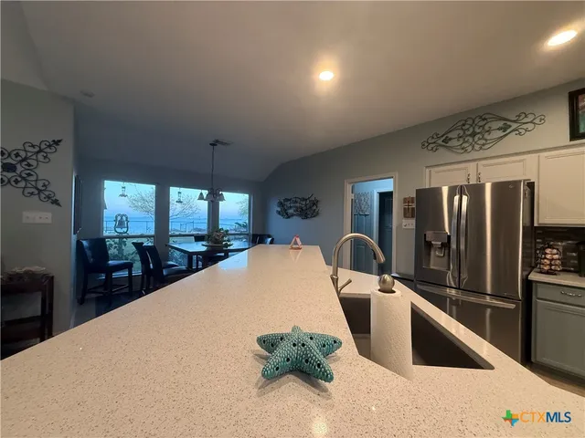 a large kitchen with stainless steel appliances granite countertop a stove a sink a refrigerator and a microwave