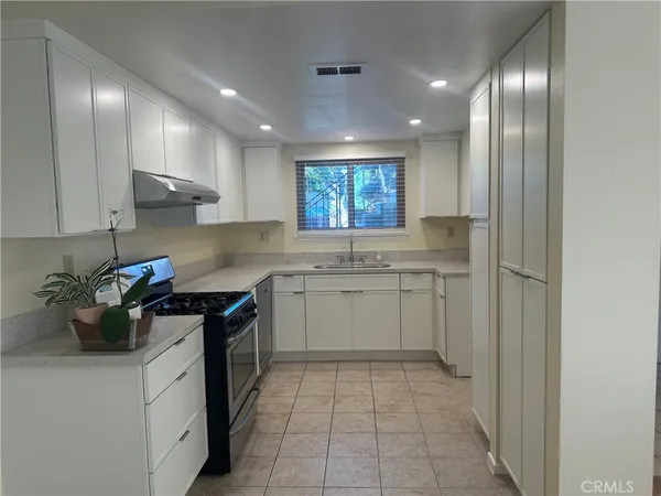 a kitchen with a sink stove and cabinets