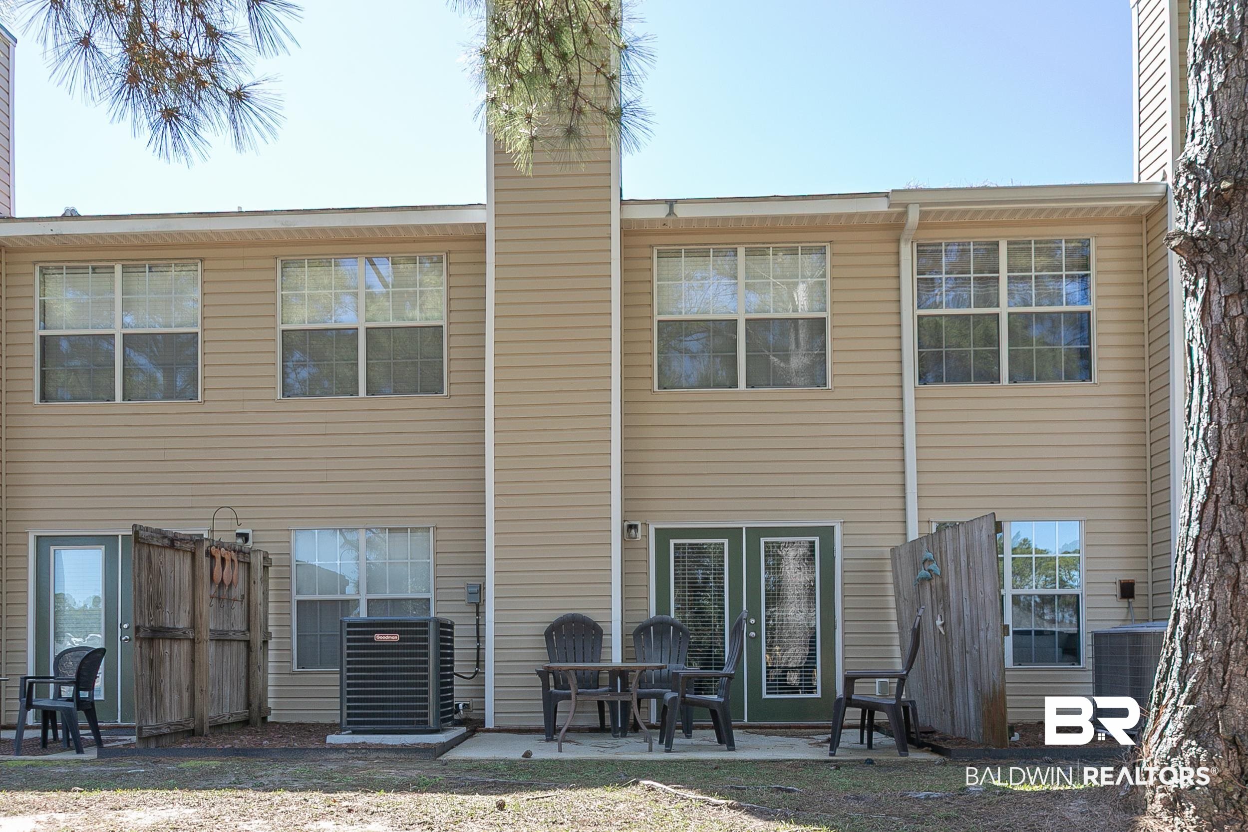 1517 Regency Road, Unit 33 Gulf Shores, AL 36542 - Photo 28 of 29 Back of house featuring cooling unit, a chimney, and a patio