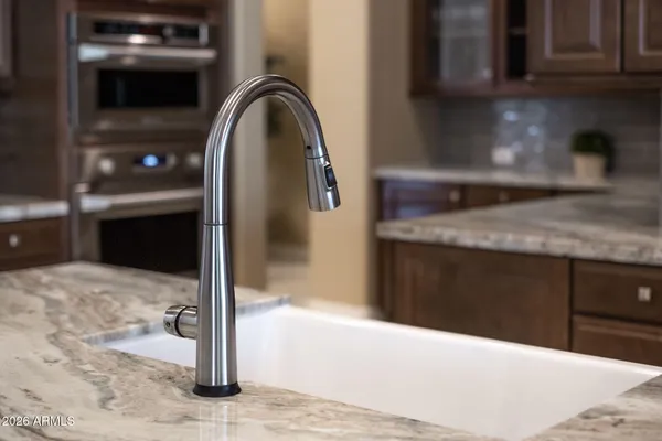 a kitchen with stainless steel appliances granite countertop a sink a stove and cabinets