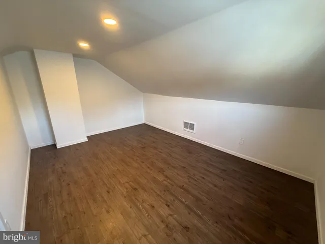 an empty room with wooden floor and entrance