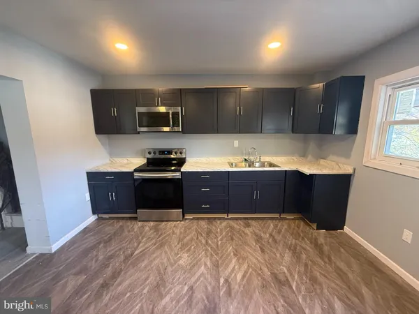 a kitchen with granite countertop a refrigerator and a stove top oven