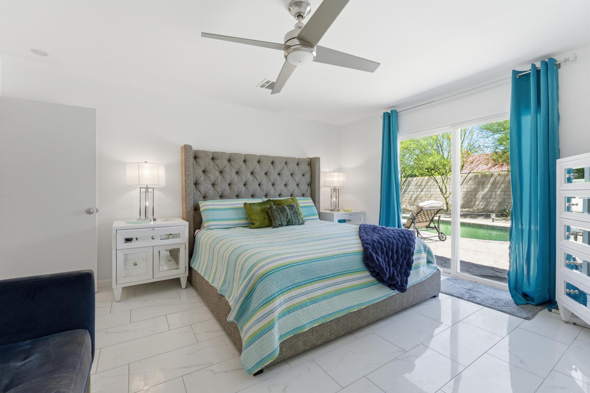 67220 Quijo Road Cathedral City, CA 92234 - Photo 17 of 26 a bedroom with a bed and large windows