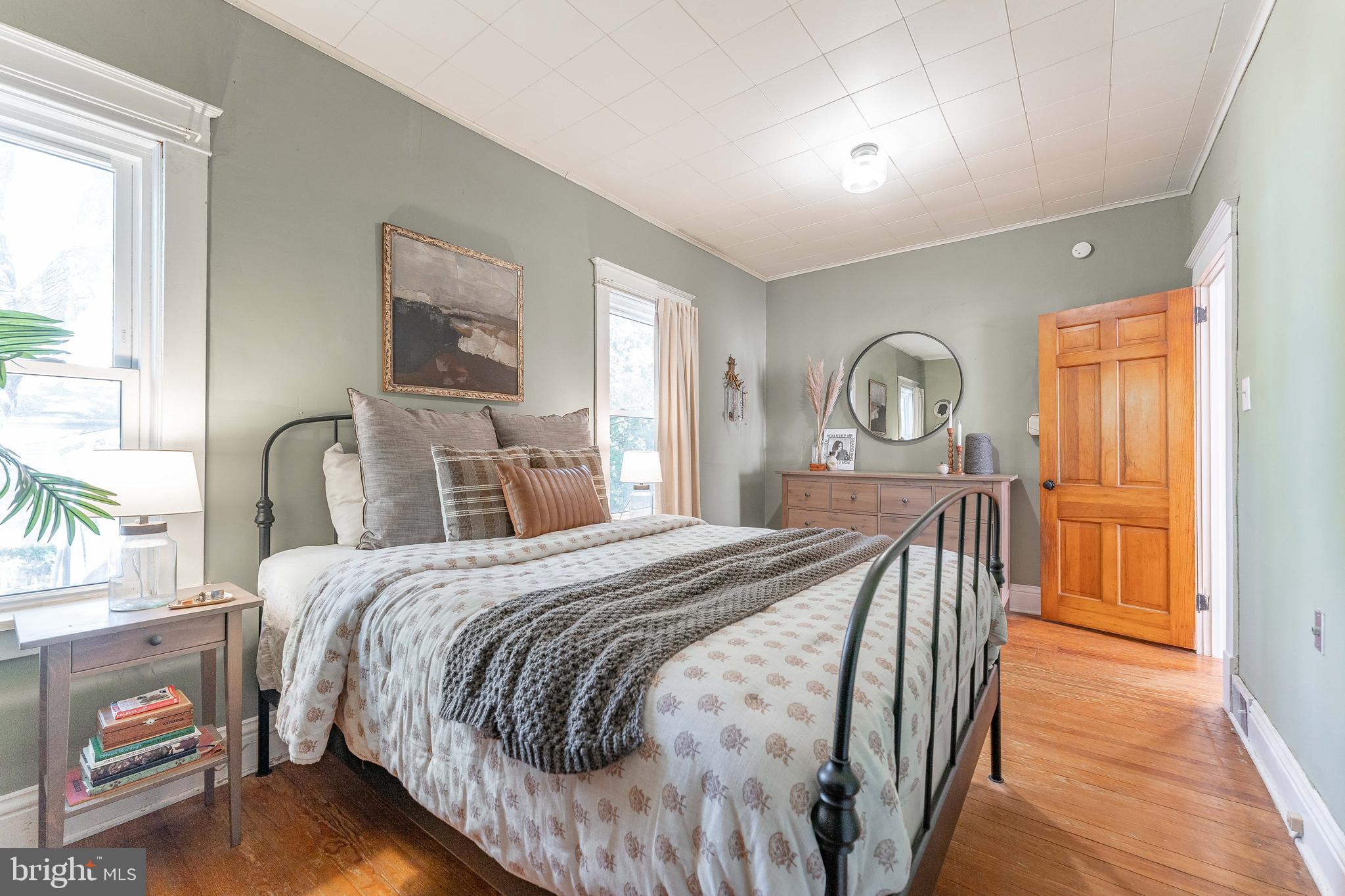 864 North Avenue Springfield, PA 19064 - Photo 27 of 33 a bedroom with a bed a mirror on dresser and a window