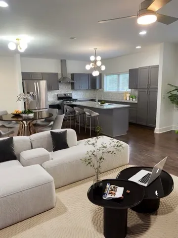 a kitchen with stainless steel appliances kitchen island granite countertop a sink a stove a dining table and chairs