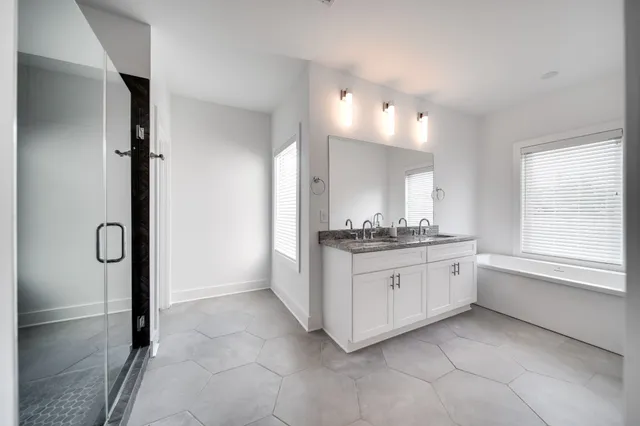 a bathroom with a granite countertop sink mirror and a bathtub