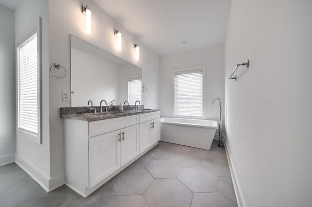 a bathroom with a bathtub sink and mirror