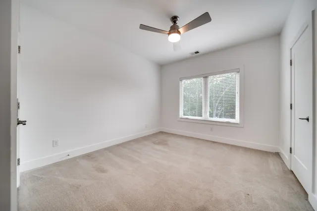 an empty room with a window and a fan
