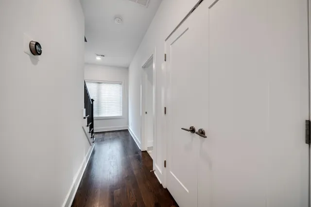 a view of a hallway with wooden floor and closet