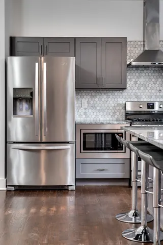 a kitchen with stainless steel appliances granite countertop a stove a refrigerator and a microwave