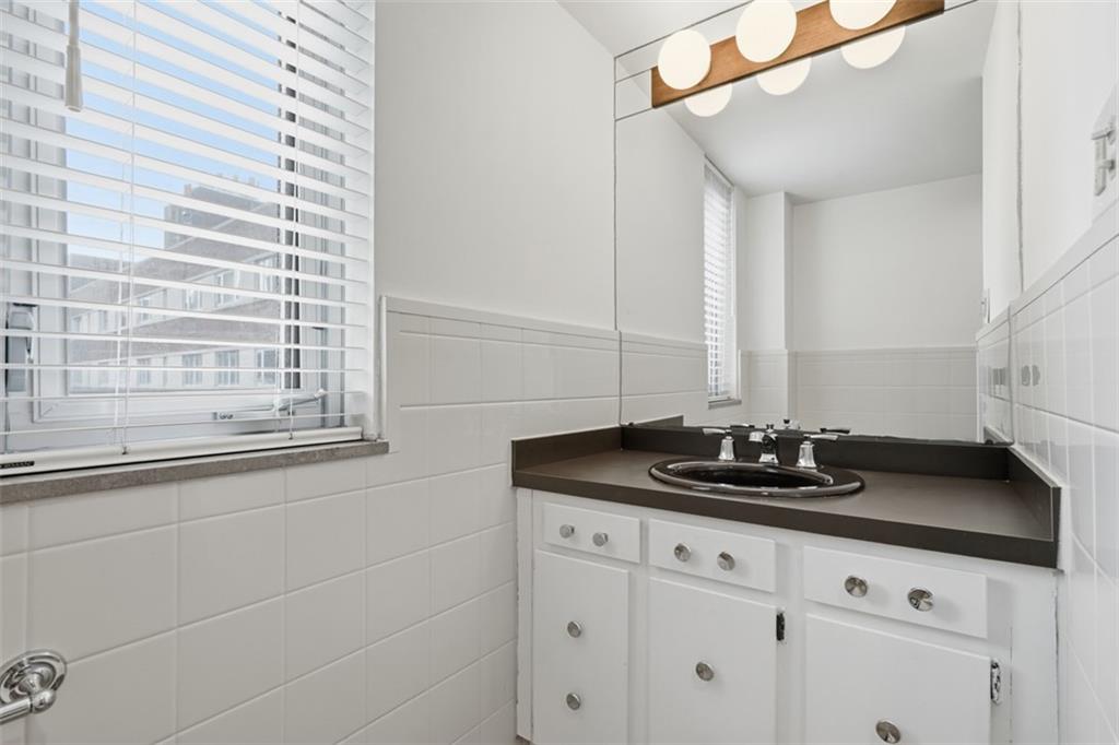 128 North Craig Street, Unit 814 Pittsburgh, PA 15213 - Photo 22 of 34 a bathroom with a granite countertop sink and a mirror