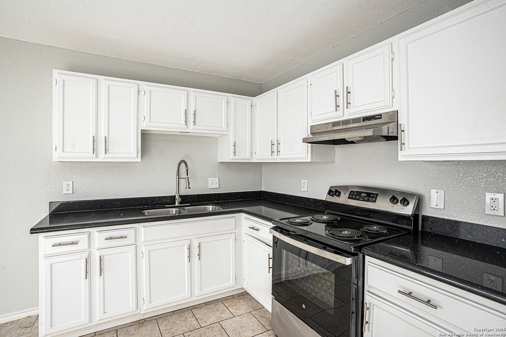 10023 Amber Field Drive San Antonio, TX 78245 - Photo 11 of 28 a kitchen with granite countertop white cabinets and appliances
