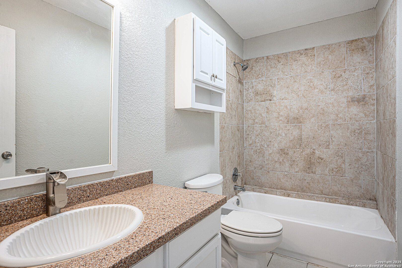 10023 Amber Field Drive San Antonio, TX 78245 - Photo 16 of 28 a bathroom with a granite countertop sink toilet and shower