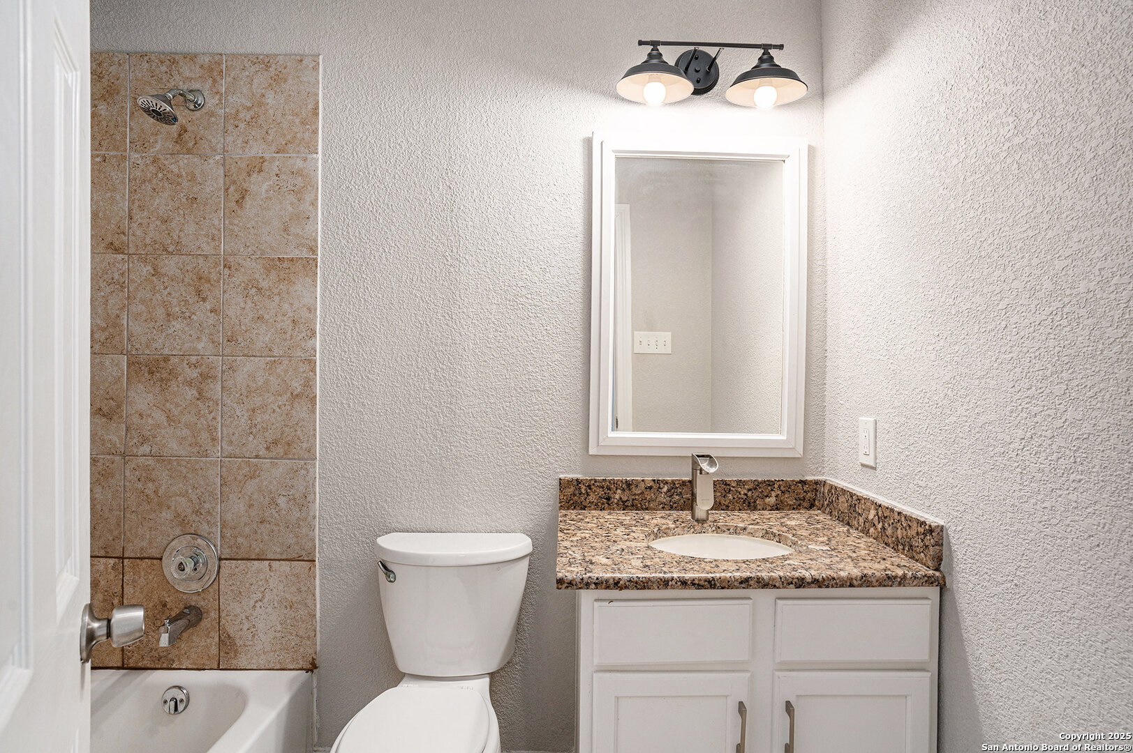 10023 Amber Field Drive San Antonio, TX 78245 - Photo 22 of 28 a bathroom with a granite countertop sink toilet and shower