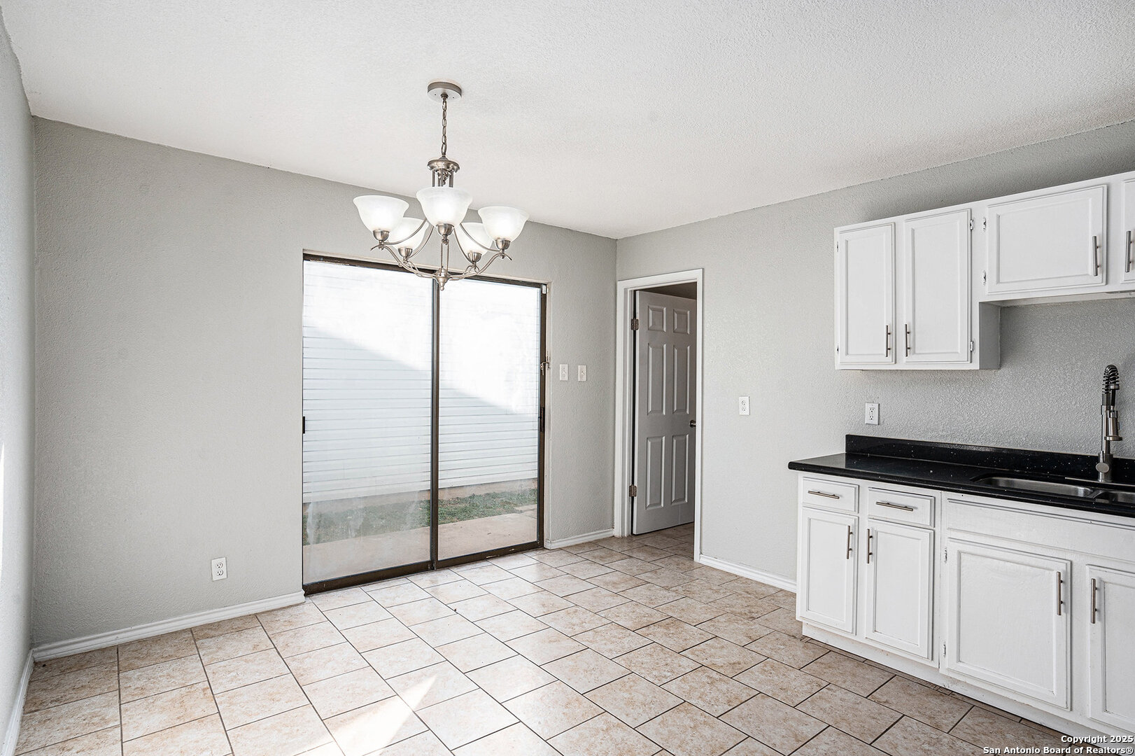 10023 Amber Field Drive San Antonio, TX 78245 - Photo 8 of 28 a kitchen with granite countertop a stove a sink and white cabinets