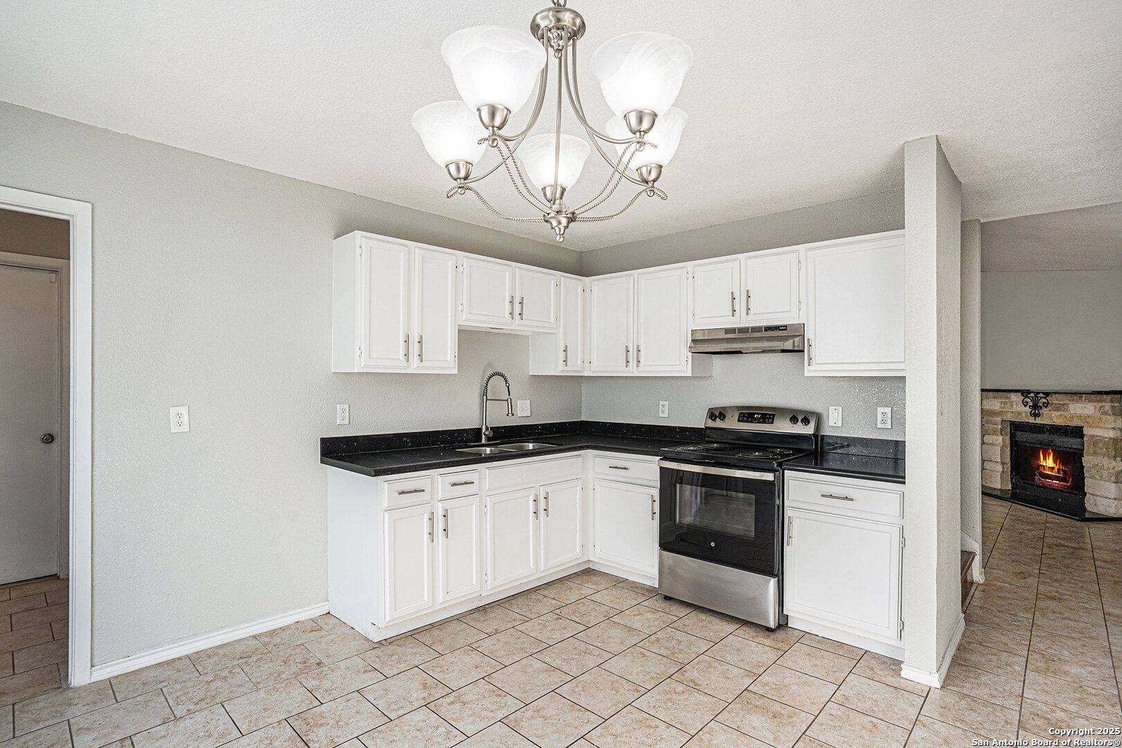 10023 Amber Field Drive San Antonio, TX 78245 - Photo 9 of 28 a kitchen with granite countertop a sink a stove and cabinets