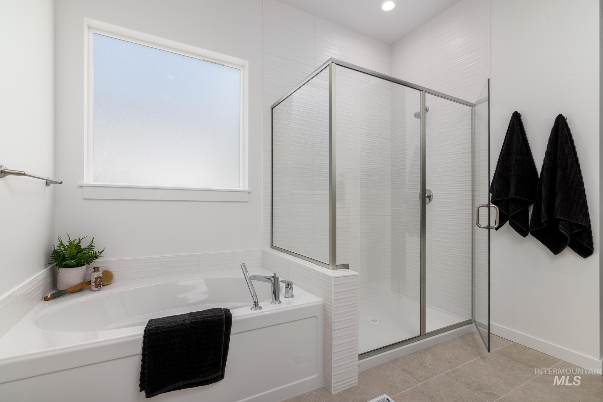 14703 Serenity Pt Street Caldwell, ID 83607 - Photo 9 of 11 Bathroom featuring a stall shower, a garden tub, light tile patterned floors, and recessed lighting
