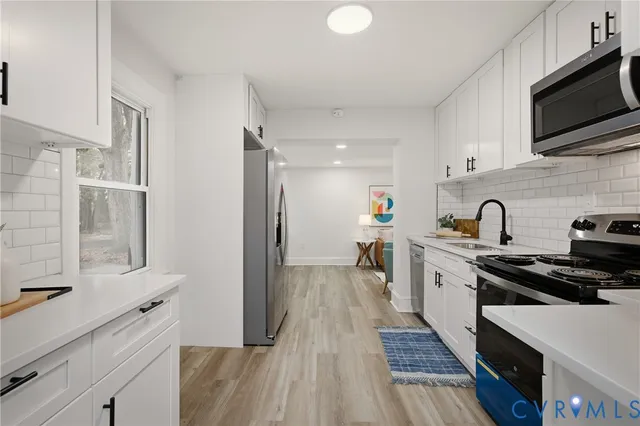 a kitchen with stainless steel appliances a sink stove and refrigerator