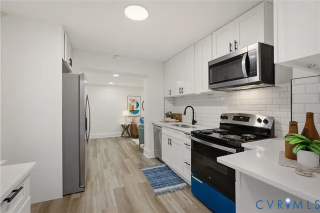 a kitchen with stainless steel appliances a stove microwave and sink