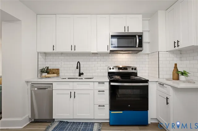 a kitchen with white cabinets and stainless steel appliances