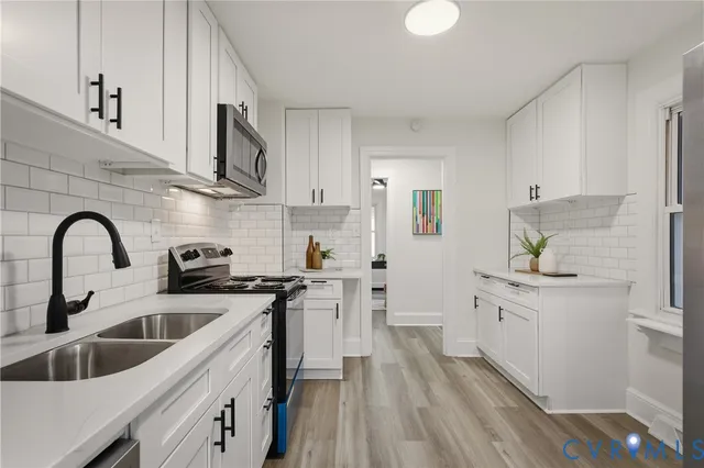 a kitchen with stainless steel appliances granite countertop a sink stove and cabinets