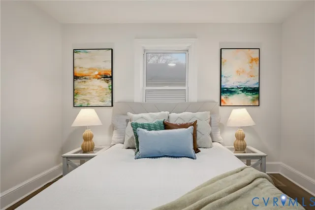 a bedroom with a bed and a painting on the wall