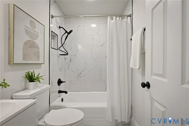 a bathroom with a toilet and a shower curtain