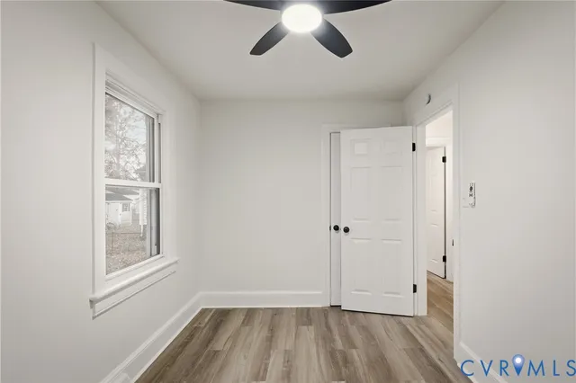 a view of empty room with wooden floor and window