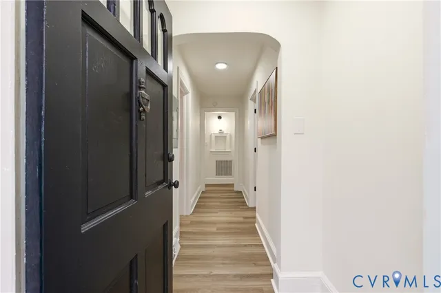 a view of a hallway with wooden floor and staircase