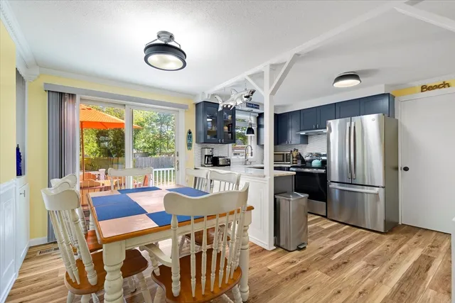 a kitchen with a table chairs refrigerator and microwave